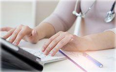 A close up of a person's hands typing on a laptop keyboard.
