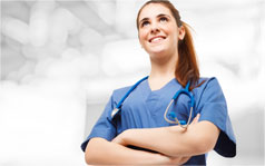 A female nurse smiling with her arms crossed.