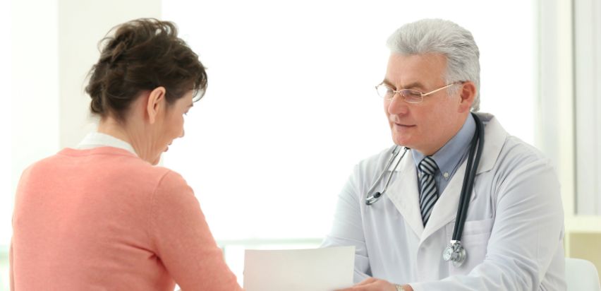 A male doctor showing documents to a female patient.