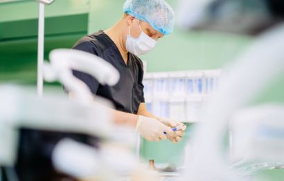 Anaesthesiologist in an operating theatre holding a syringe