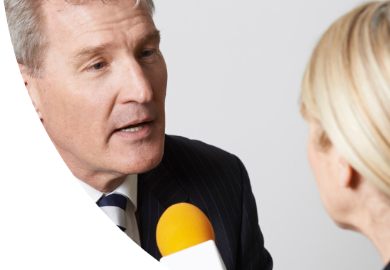 A female interviewer holding a microphone and interviewing a man.