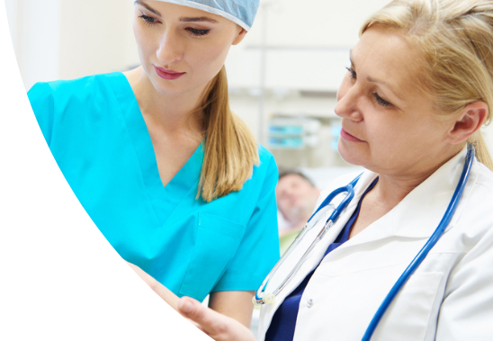 Two female medical professionals looking a patient chart.
